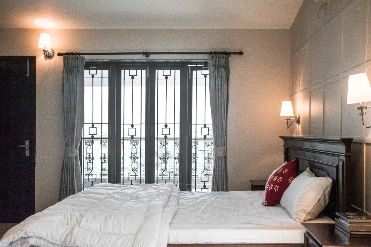 Bedroom with wrought-iron balcony doors — Carpe Diem, Lonavala