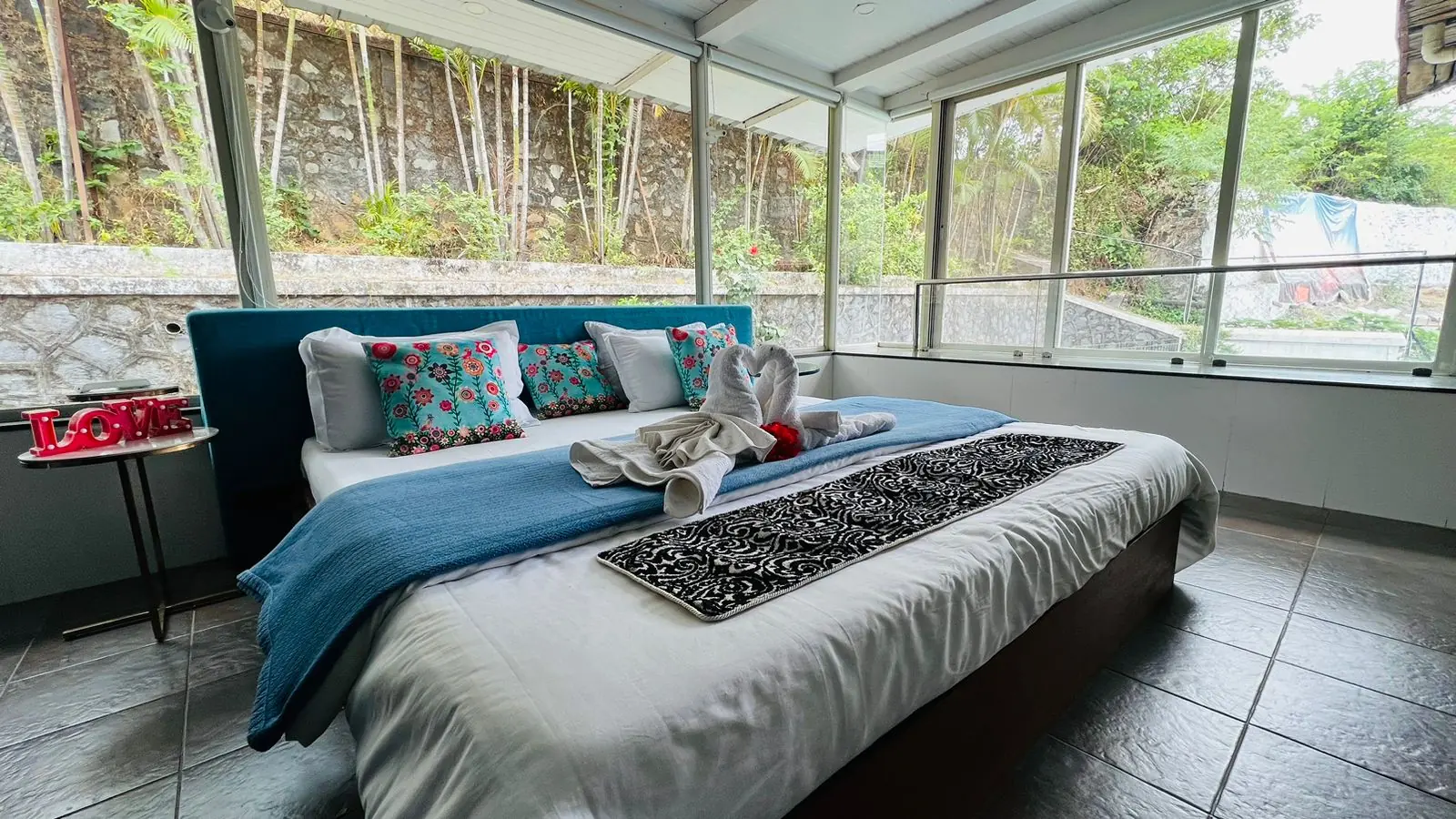 Glass-walled bedroom opening into the greenery — Carpe Diem, Lonavala