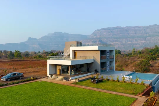 Lawn, pool and the Sahyadri ridgeline — Majestic Cascade Villa, Karjat