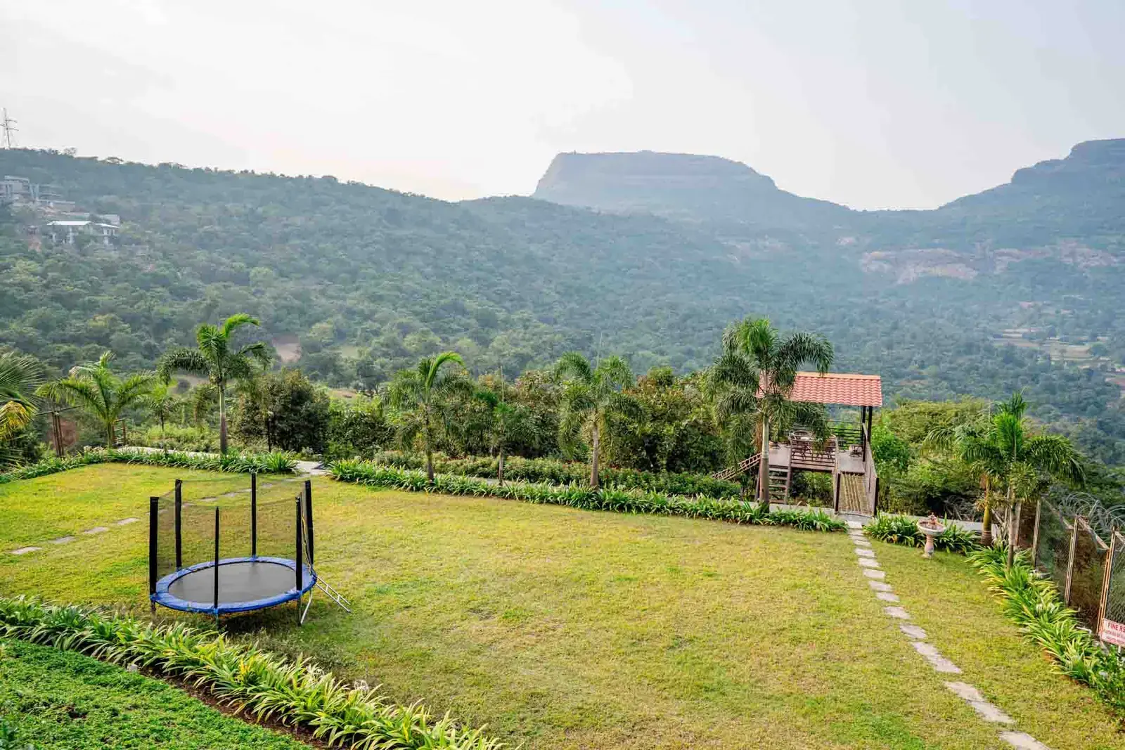 Landscaped lawn with trampoline and machan — Mantra 147, Pawna Lake, Lonavala