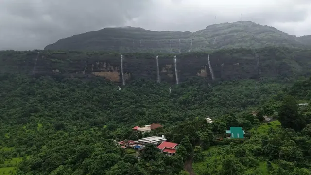 Waterfalls opening across the facing escarpment in monsoon — Misty Cascades, Karjat